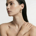 Single Clarte gold hoop shown worn, showing the freshwater pearl cluster
